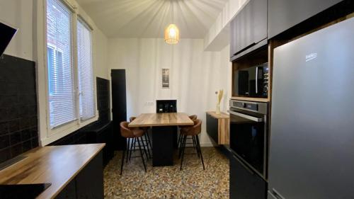 a kitchen with a table and chairs in a room at In the heart of Rennes - 10P in Rennes