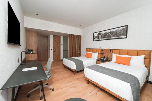 a hotel room with two beds and a desk at Galeria Plaza Leon in León