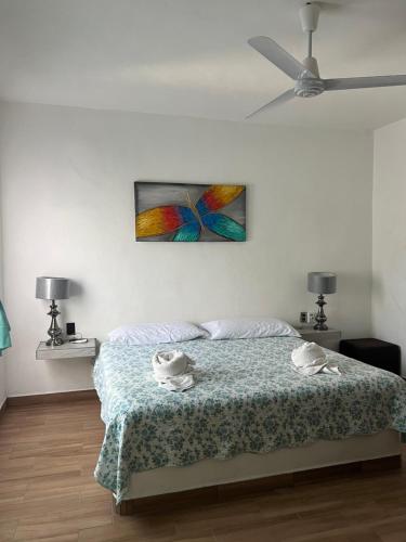 1 dormitorio con 1 cama con una pintura en la pared en Villas las Palmeras Casa Canaria 12 personas, en La Manzanilla