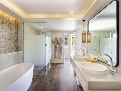 a bathroom with two sinks and two mirrors at Sofitel Fiji Resort & Spa in Denarau