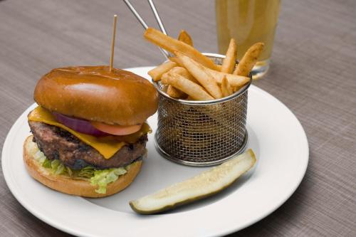 a plate with a hamburger and french fries and a pickle at SpringHill Suites by Marriott Las Vegas Convention Center in Las Vegas