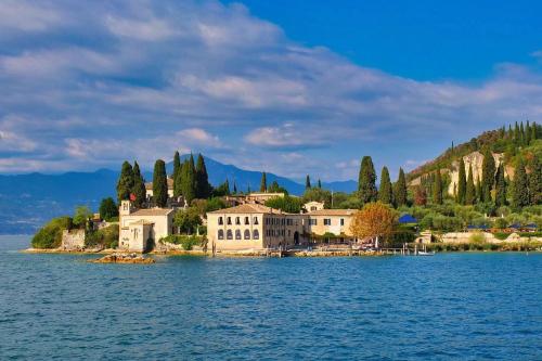 a house on an island in the middle of the water at Villa sogno Garda lake in Tenno