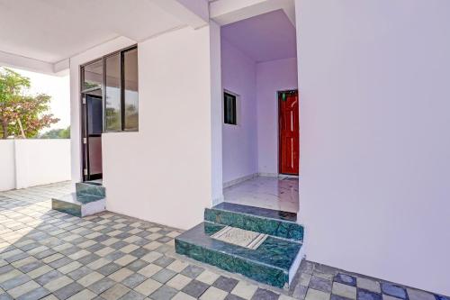 Habitación con puerta roja y suelo de baldosa. en OYO Hotel R R, en Nagpur
