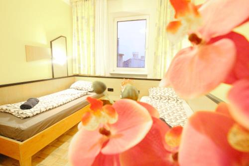 a bedroom with two beds and flowers in the foreground at Double Room in Hütteldorfer Straße Area in Vienna