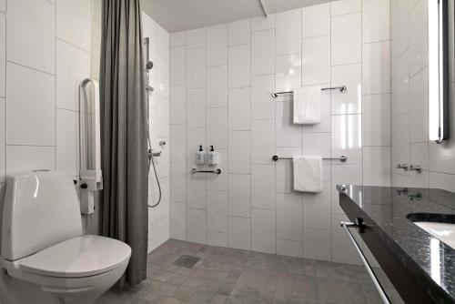 La salle de bains blanche est pourvue de toilettes et d'un lavabo. dans l'établissement Scandic Europa, à Göteborg
