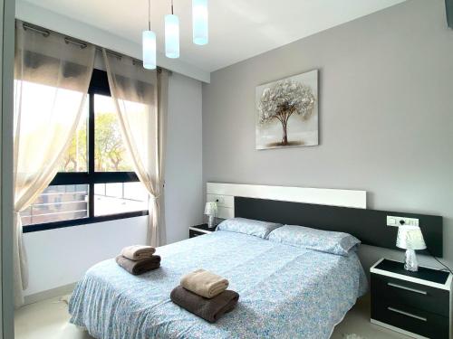 a bedroom with a bed with two towels on it at Precioso apartamento a tan solo 300 m de la playa in Pilar de la Horadada