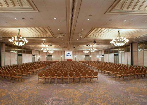 a large room with rows of chairs and chandeliers at Hilton Nicosia in Nicosia