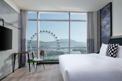 a hotel room with a bed and a large window at Moxy Qiandao Lake in Chun'an