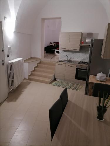a living room with a kitchen and a dining table at Lips House in Gravina in Puglia