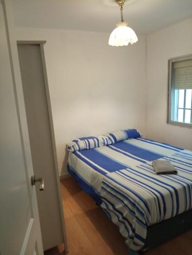 馬德里的住宿－Apartamento 3 Dormitorios en Sanchez Preciados，一间卧室配有一张蓝色和白色条纹的床