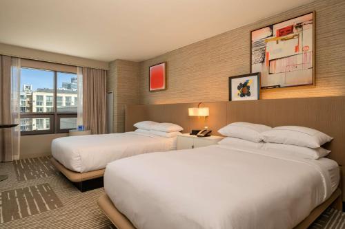 a hotel room with two beds and a window at Hilton San Diego Gaslamp Quarter in San Diego