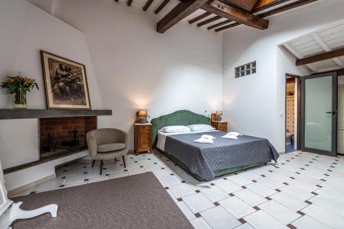 a bedroom with a bed and a chair and a fireplace at Cortile Santa Monaca in Florence
