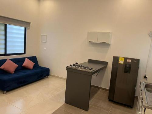 a living room with a blue couch and a kitchen at Hotel Suites Cristo Rey in Cali