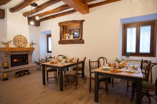 a dining room with two tables and a fireplace at Casa Rural Kabia in Arráyoz