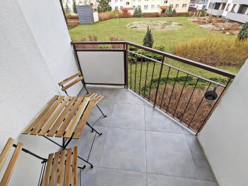 a balcony with two benches and a view of a yard at Misia Casa - Ultra-Modern Spotless Apartment in Historic Torun in Toruń