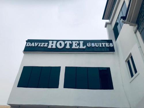 DAVIZZ HOTEL AND SUITES في أسابا: علامة على جانب المبنى