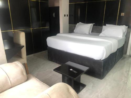 アサバにあるDAVIZZ HOTEL AND SUITESのソファとテーブル付きの客室の大型ベッド1台分です。