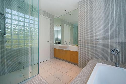 a bathroom with a glass shower and a sink at Diamond View in Sorrento