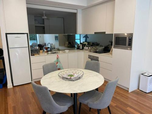een keuken met een tafel en stoelen in een kamer bij One Bedroom Self Catering Eden in Sydney