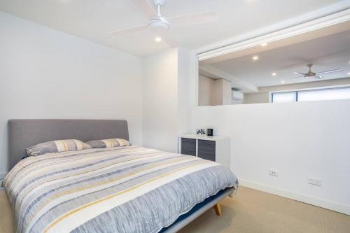 een witte slaapkamer met een bed en een raam bij One Bedroom Self Catering Eden in Sydney
