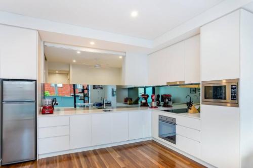een grote keuken met witte kasten en toiletartikelen bij One Bedroom Self Catering Eden in Sydney