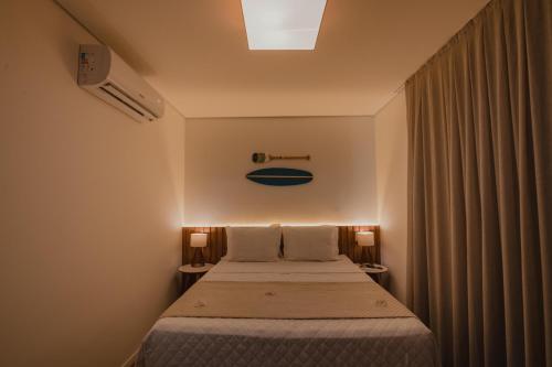 1 dormitorio pequeño con 1 cama con 2 lámparas en POUSADA AMAR NORONHA, en Fernando de Noronha