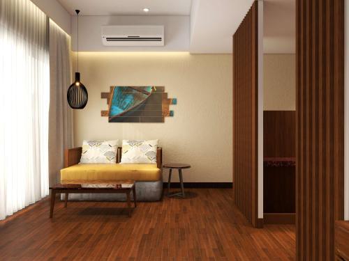 a living room with a yellow bed and a table at Park Inn by Radisson Goa Candolim in Candolim