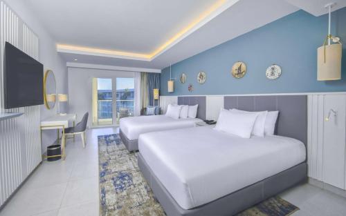 a hotel room with two beds and a desk at Hilton Skanes Monastir Beach Resort in Monastir
