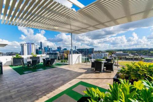 a patio with tables and chairs on a roof at Pavillion on Brookes in Brisbane