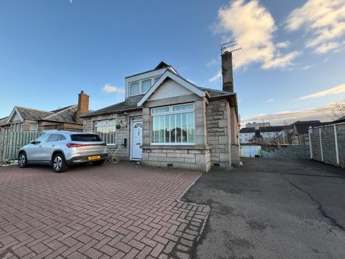 a car parked in front of a house at Netherby Guest House Edinburgh in Edinburgh