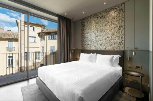 a bedroom with a large bed and a large window at Radisson Collection Hotel, Roma Antica in Rome