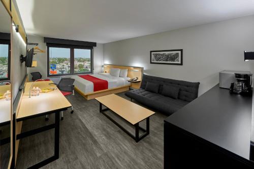a hotel room with a bed and a couch at City Express by Marriott Mexicali in Mexicali