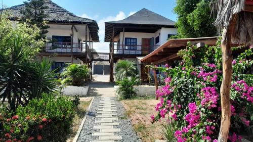 een pad voor een huis met bloemen bij Sand Castle Ocean Suites in Zorritos