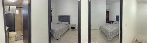 - une chambre avec 2 lits et un miroir dans l'établissement Apartamentos Tampico-Altamira, 