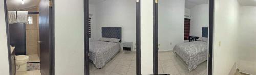 a bedroom with two beds and a mirror at Apartamentos Tampico-Altamira in Guásima