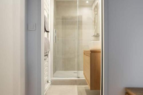 une salle de bain blanche avec une douche et un lavabo dans l'établissement Le QUAI Paris-Boulogne-île Saint Germain au calme avec parking, à Boulogne-Billancourt