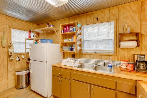 a kitchen with a white refrigerator and a sink at Cozy Riverfront Cabin about 2 Mi to Main Street Hardy in Hardy