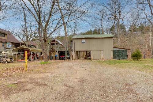 a large building with a garage next to a house at Cozy Riverfront Cabin about 2 Mi to Main Street Hardy in Hardy