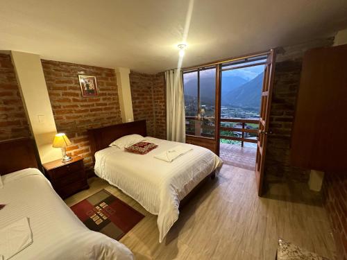 a bedroom with a bed and a large window at Spa Hotel Etelvina in Quillullaco