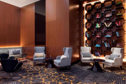 a waiting room at a hotel with chairs and tables at Sydney Harbour Marriott Hotel at Circular Quay in Sydney