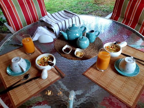 - une table en verre avec des aliments pour le petit-déjeuner et du jus d'orange dans l'établissement Casa - Hospedaje Munay Ki - Yoga -, à Pisco