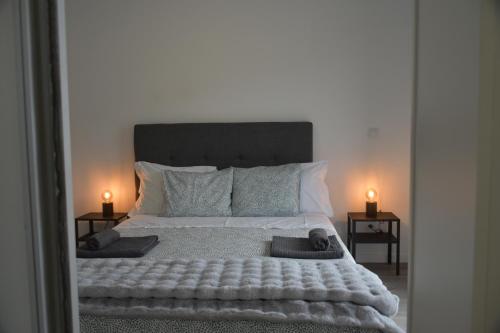 een slaapkamer met een groot bed met 2 kaarsen op tafels bij CASA FLIPE t2 in Bragança