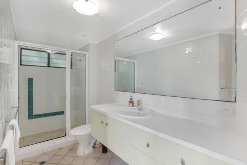 a bathroom with a sink and a toilet and a mirror at Aaronvale in Point Lookout