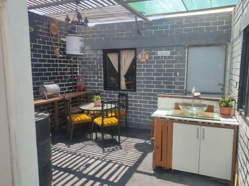 an outdoor kitchen with a table and chairs and a window at Beach House SantaElena in Pisco