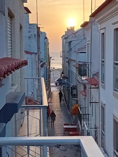 a group of people walking down a street near the ocean at Chalas bedroom in Nazaré