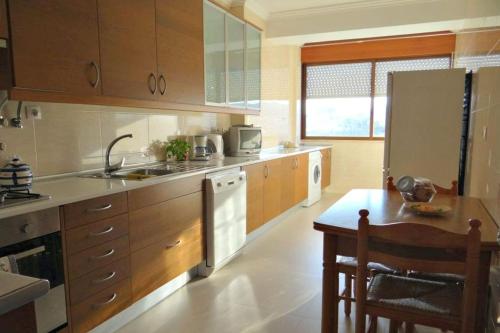 cocina con fregadero, nevera y mesa en Be Local - Apartment with 2 bedrooms in Infantado in Loures en Loures