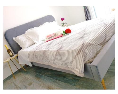 a white bed with a red rose on top of it at Chic in Fiumicino