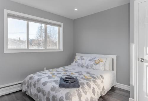 Habitación blanca con cama y ventana en Modern Downtown 3BR 2B Home, en Yellowknife