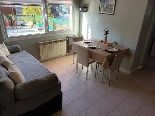 ein Wohnzimmer mit einem Tisch und einem Sofa sowie ein Esszimmer in der Unterkunft Buenavida Guesthouse in Ushuaia