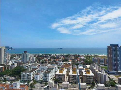 uma vista para uma cidade com edifícios e o oceano em APARTAMENTO NOVO A 600 Metros da PRAIA no Guarujá